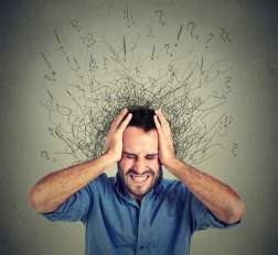 a man clutching his head in pain with squigly lines drawn around him